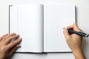 Empty note book with man hands hold a pen