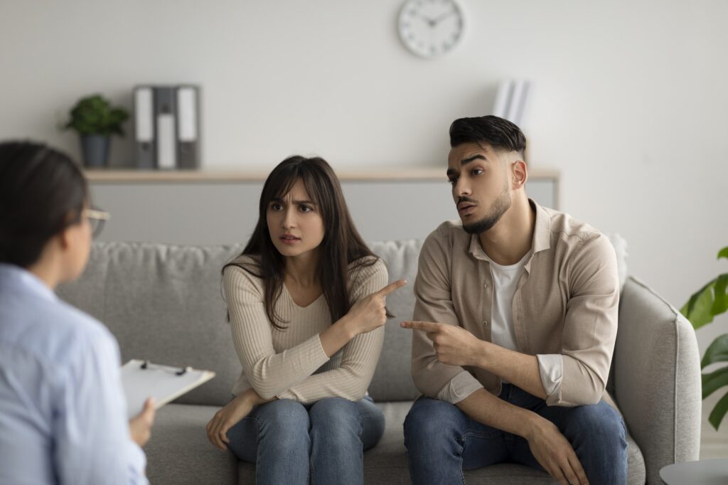 Unhappy arab spouses blaming each other in relationship problems on meeting with marital counselor